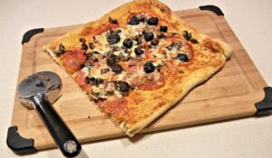 Pizza fatta in casa con impasto gommoso, evidenziando la consistenza e la farina utilizzata.