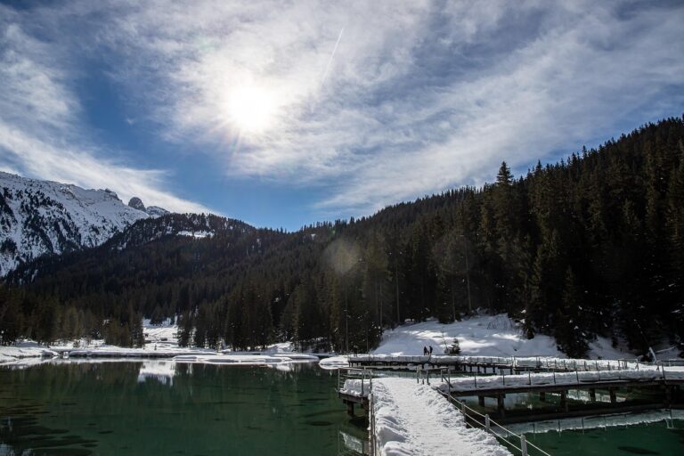 Lago turchese circondato da montagne dolomitiche, immerso nella natura e privo di turisti.