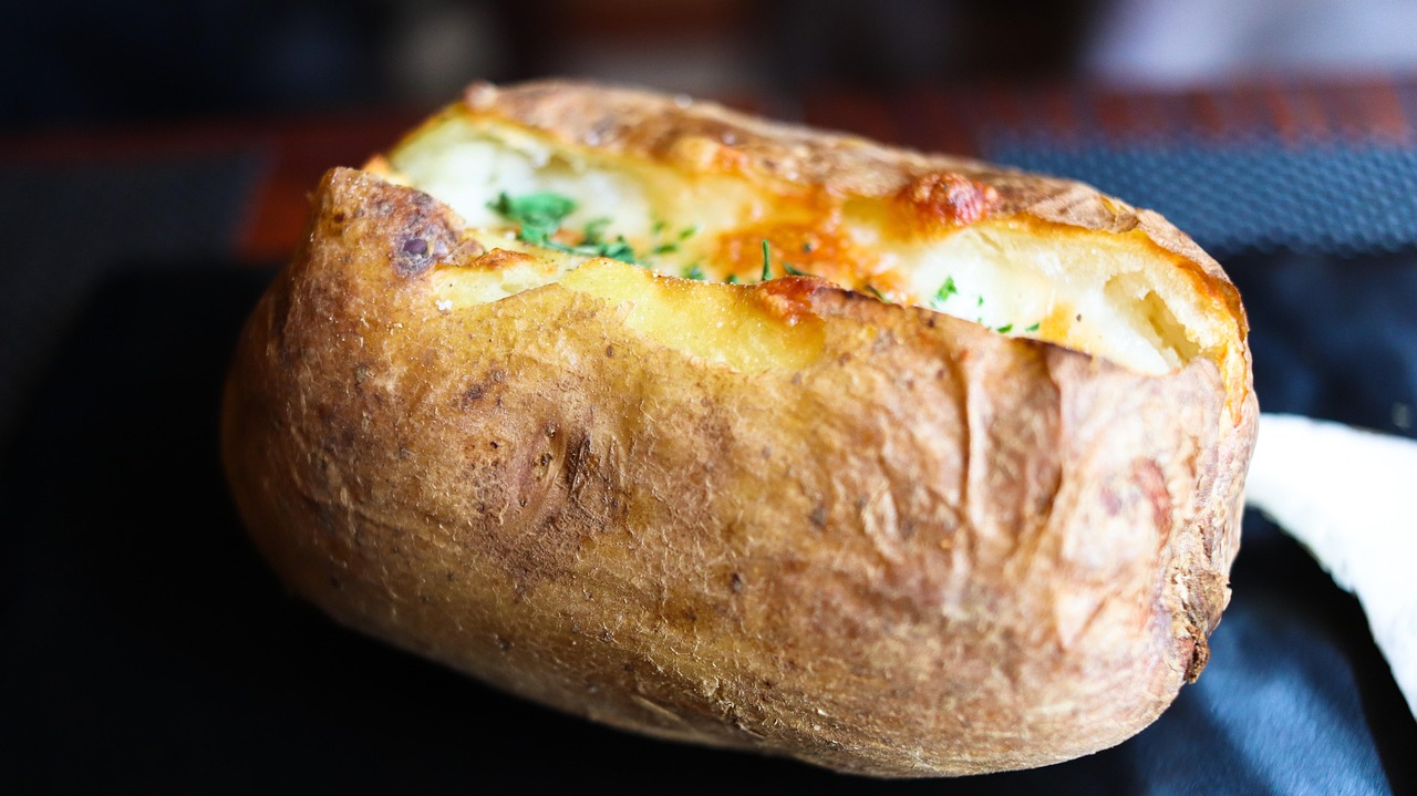 Patate al forno dorate e croccanti, disposte su una teglia senza attaccarsi.